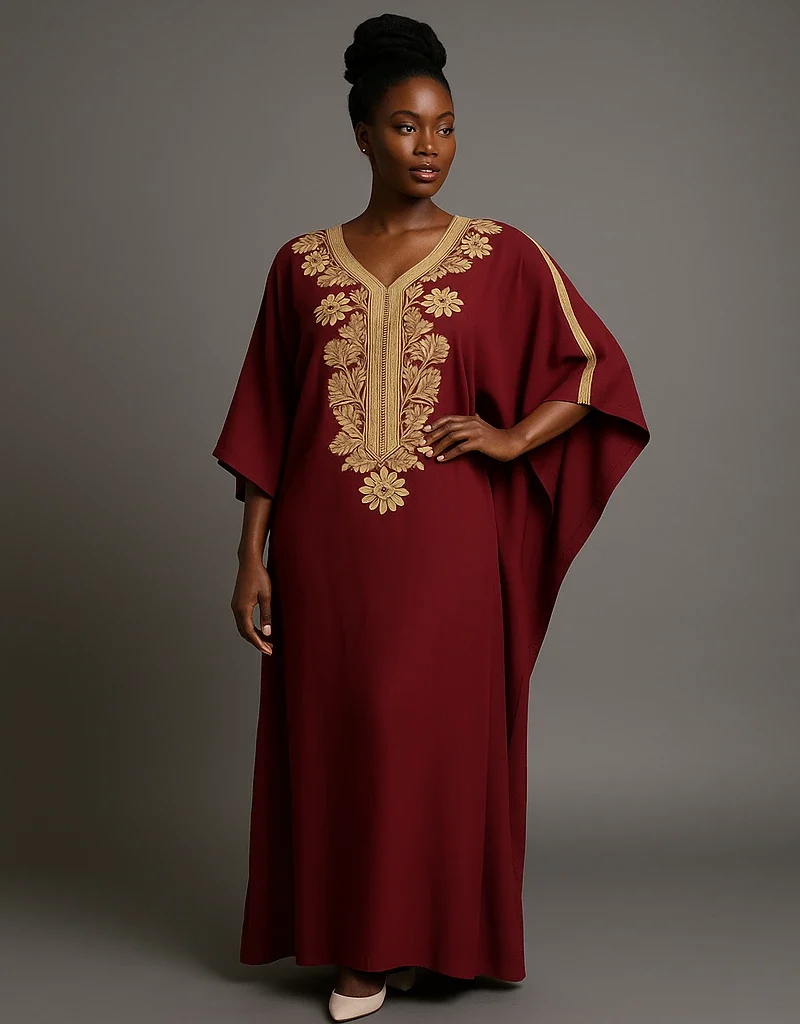 Caftan marocain grenat brodé d’or porté par une femme africaine élégante.