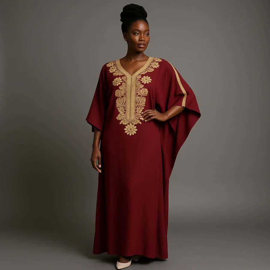 Caftan marocain grenat brodé d’or porté par une femme africaine élégante.