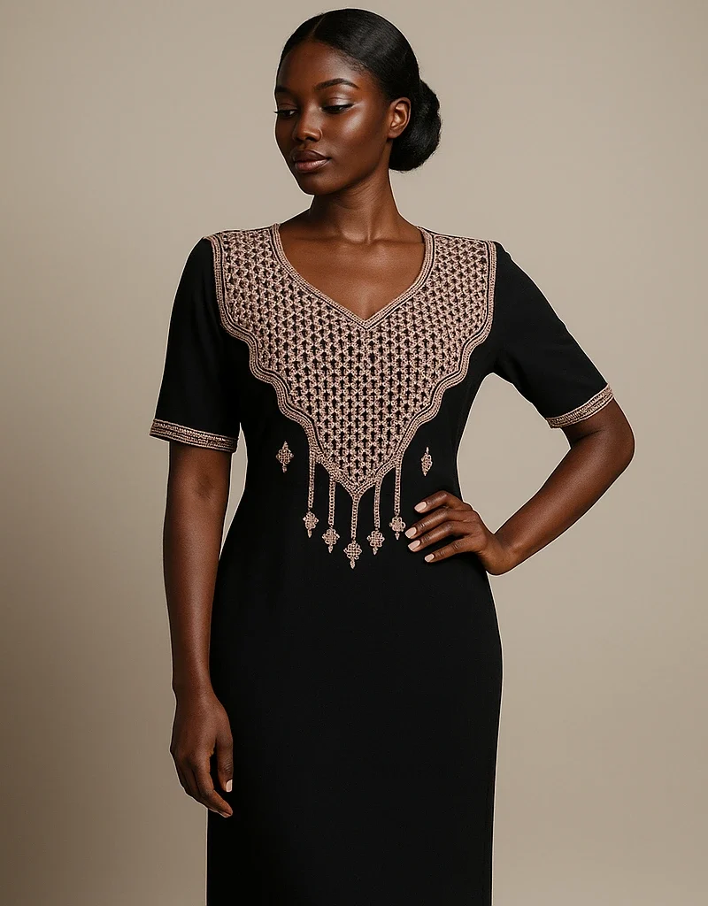 Caftan noir marocain brodé doré, porté avec élégance par une femme africaine, vu en trois-quarts.
