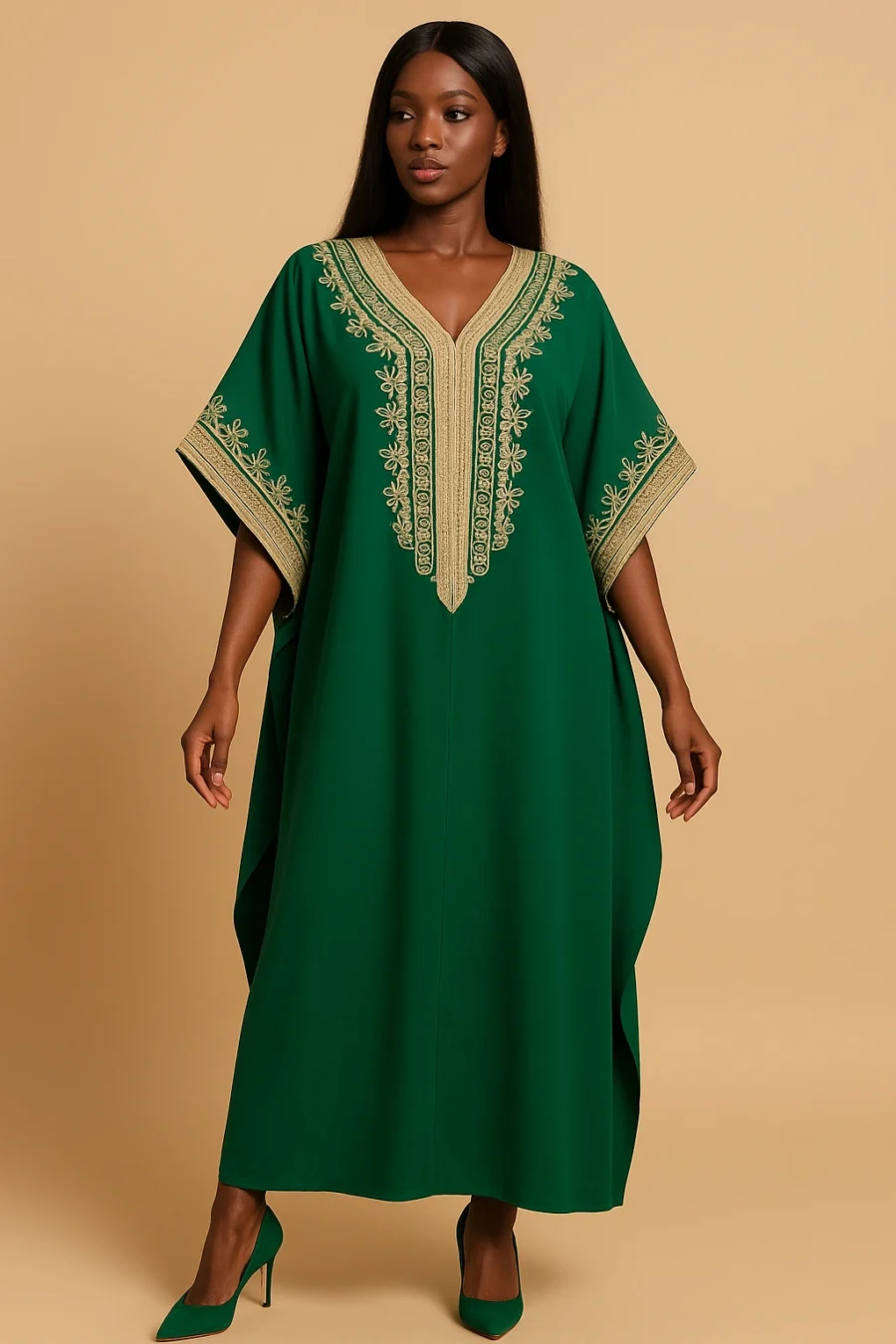 Femme ivoirienne élégante portant un caftan marocain vert émeraude avec broderie dorée artisanale, coupe ample et manches papillon, posant dans un studio beige avec escarpins assortis.